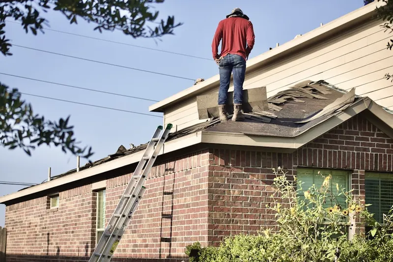 Professional roofer working on a residential roof in Delps